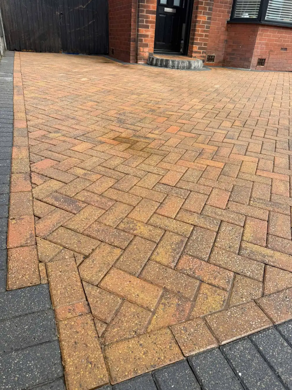 The same herringbone driveway after cleaning, warm colour restored