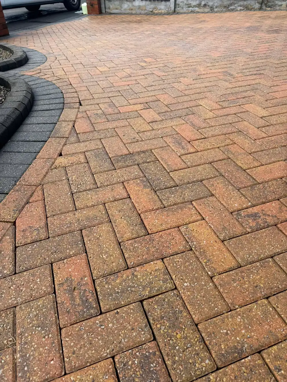 The same block driveway after cleaning, red and charcoal sharp again