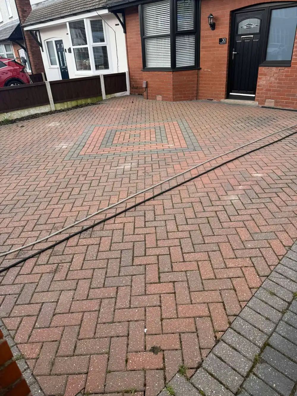 Block paved driveway covered in moss before cleaning