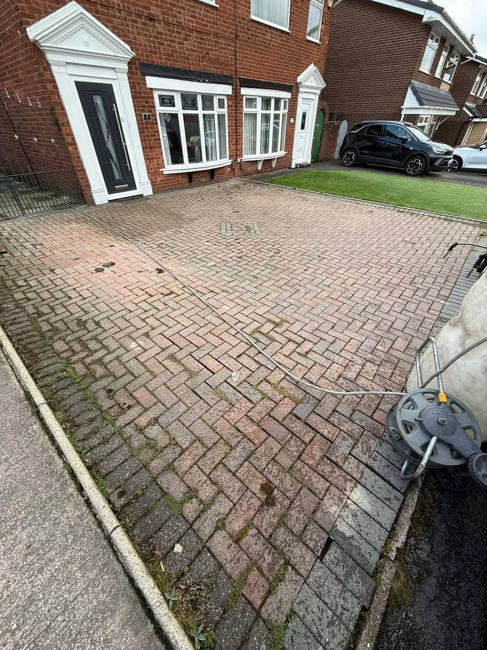 Weathered block paving driveway before cleaning