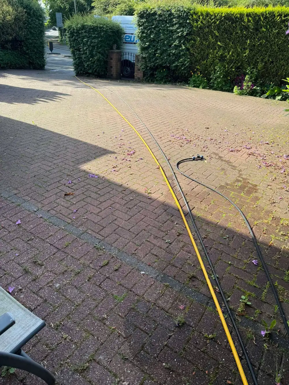 Dirty block paving driveway with weeds before cleaning