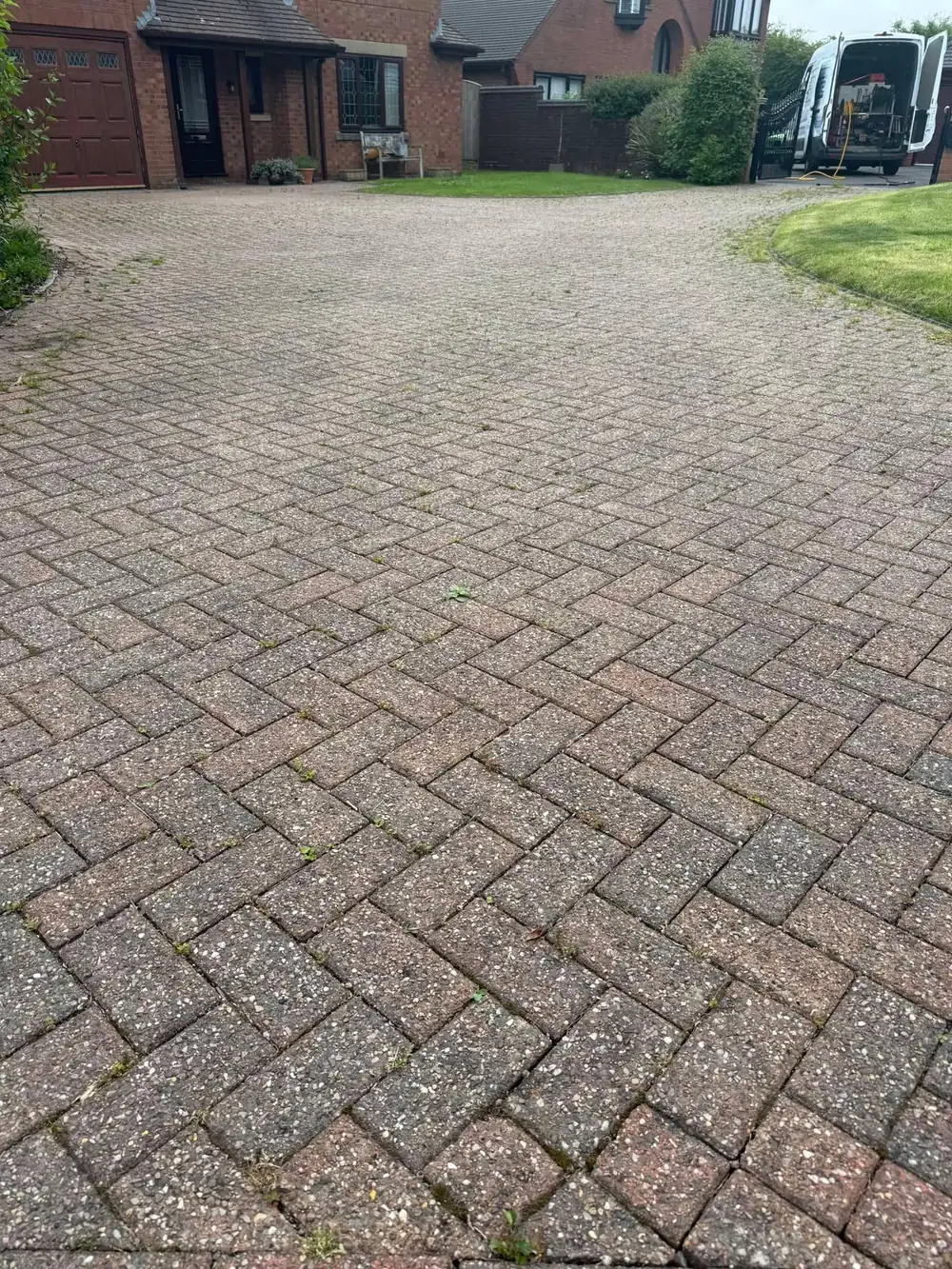 Grey, weathered block paving driveway before cleaning