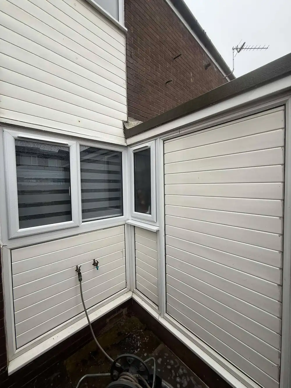 The same uPVC cladding after soft washing, bright white finish