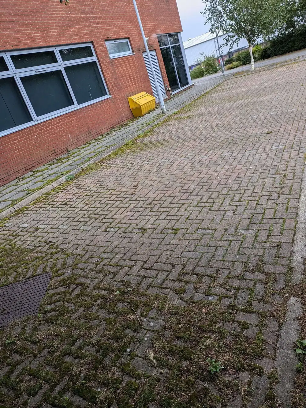 Weathered office block paving before cleaning