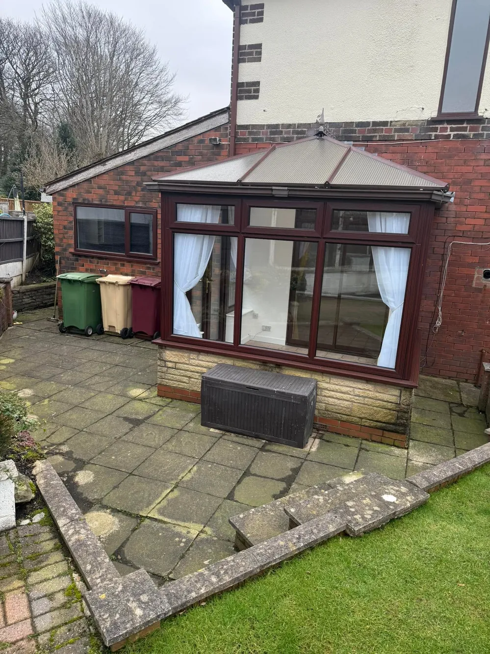 Grimy uPVC conservatory and dirty patio slabs before cleaning