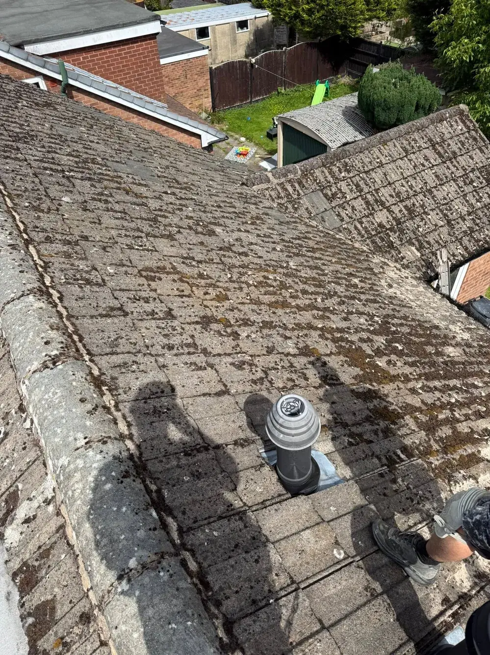 Dirty concrete roof tiles by the chimney before cleaning