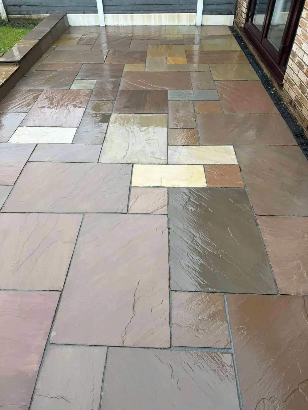 The same sandstone patio after cleaning, rich autumn colours restored