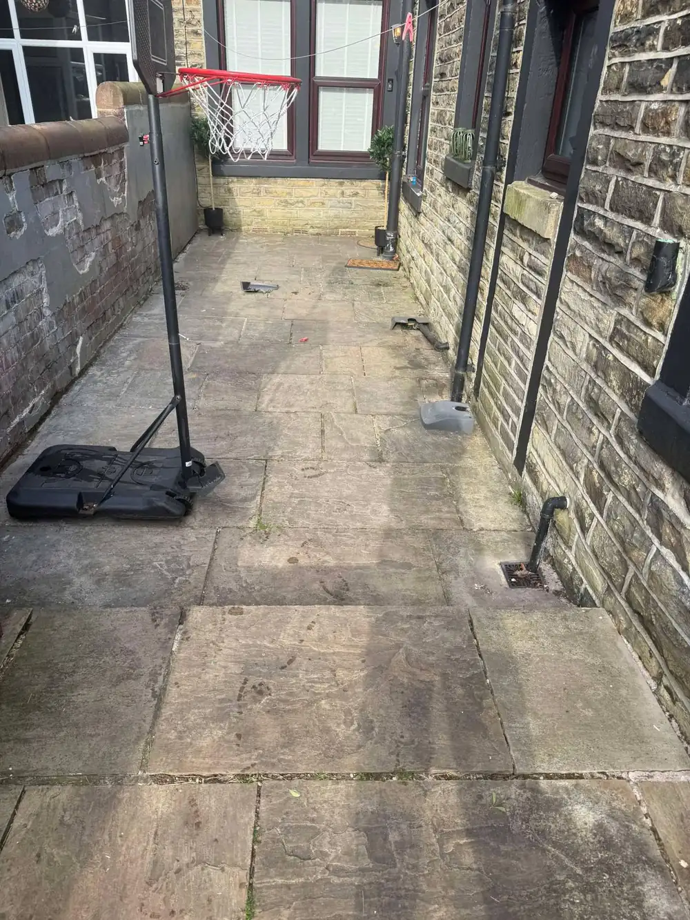 Grey, worn riven sandstone flags before cleaning