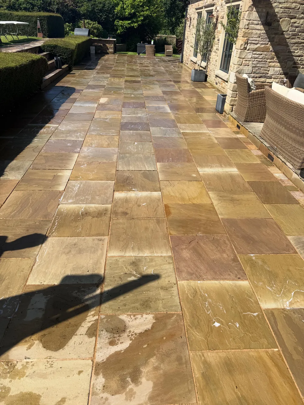 The same sandstone patio after cleaning, golden colour restored