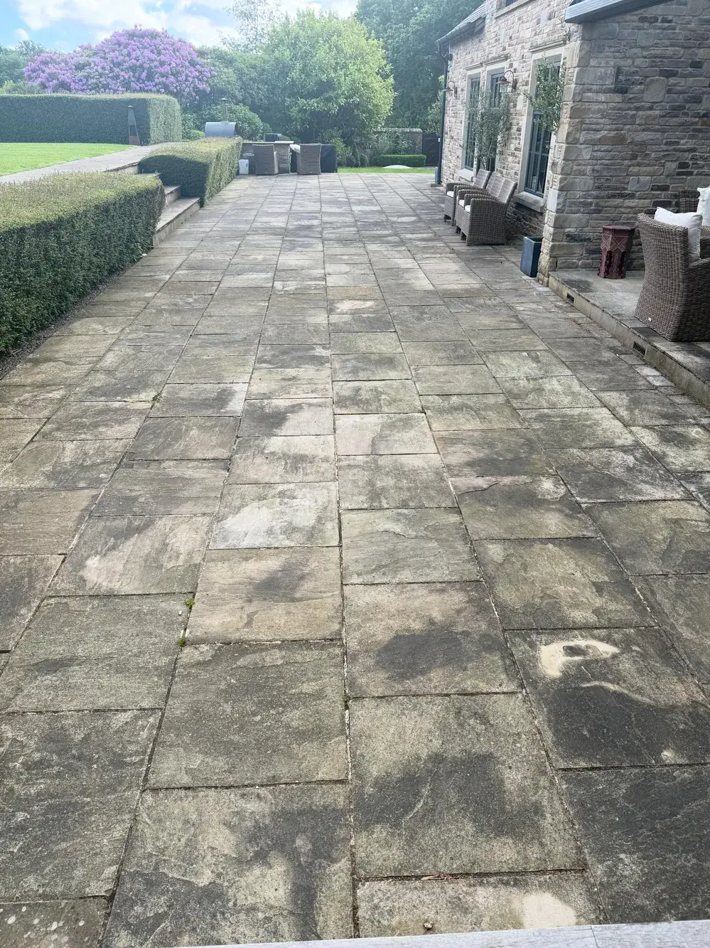 Long grey weathered sandstone patio before pressure washing