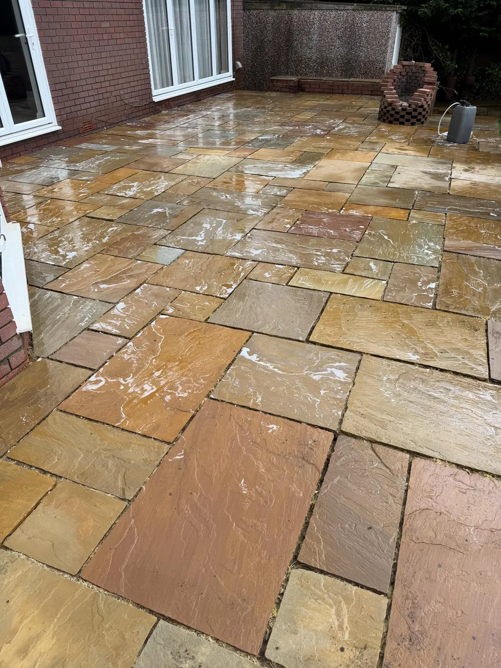 The same area transformed into a clean golden sandstone patio
