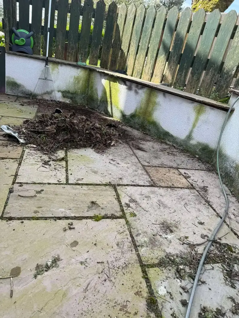 Indian sandstone patio covered in dirt and debris before pressure washing