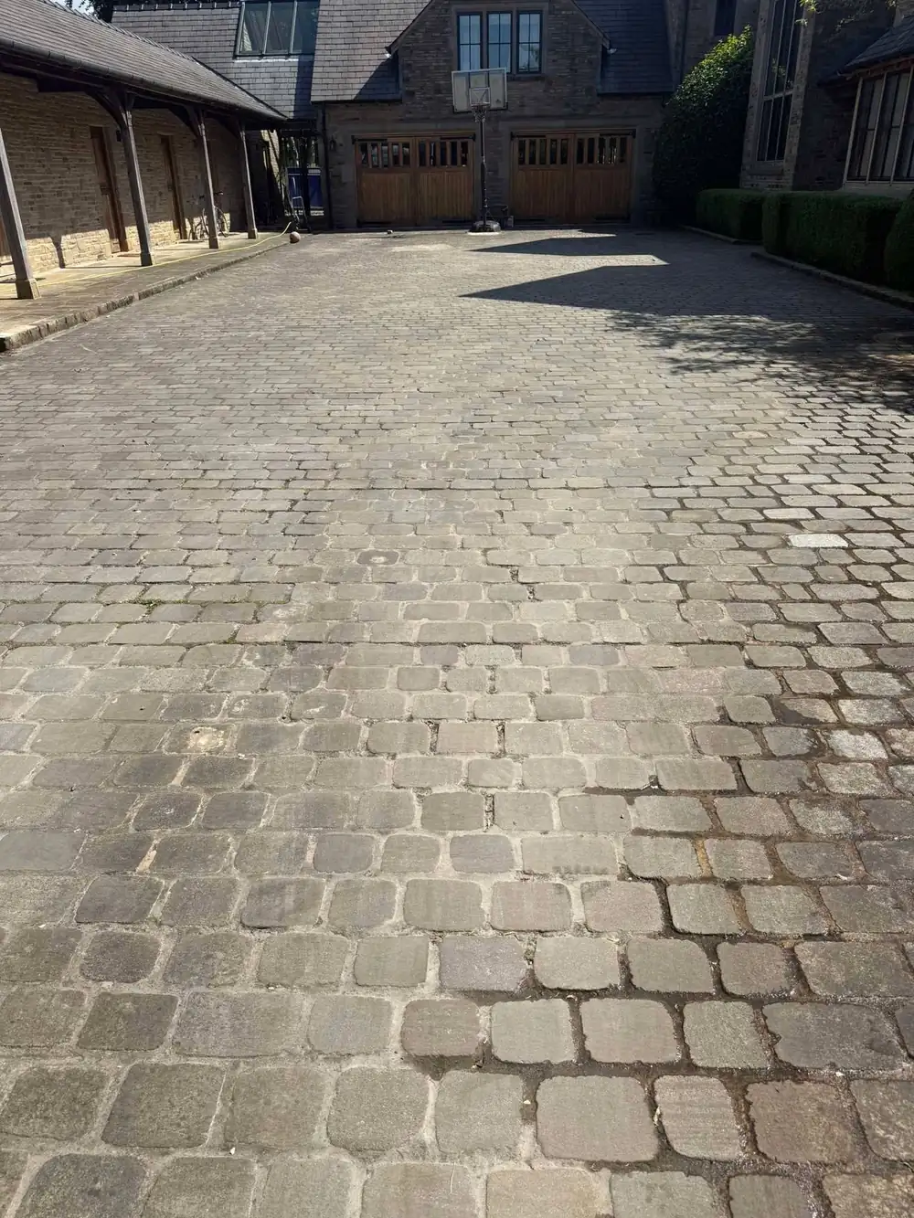 Stone setts courtyard darkened by dirt before cleaning