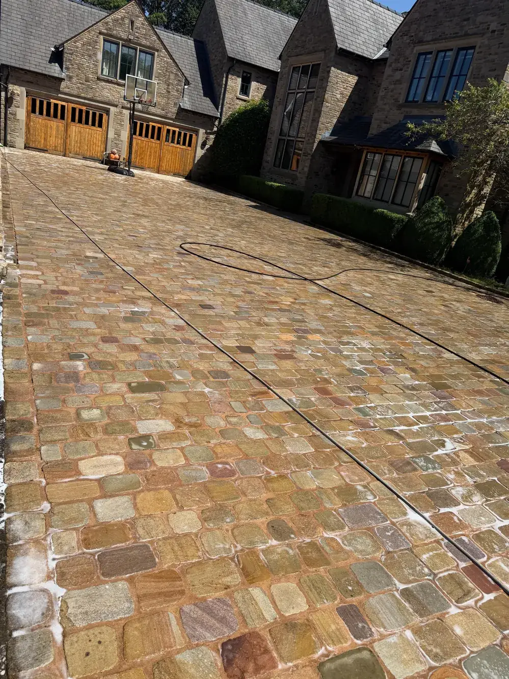 The same setts driveway after cleaning, golden stone revealed
