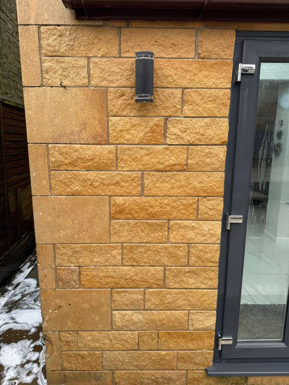 The same stonework after cleaning, golden stone revealed
